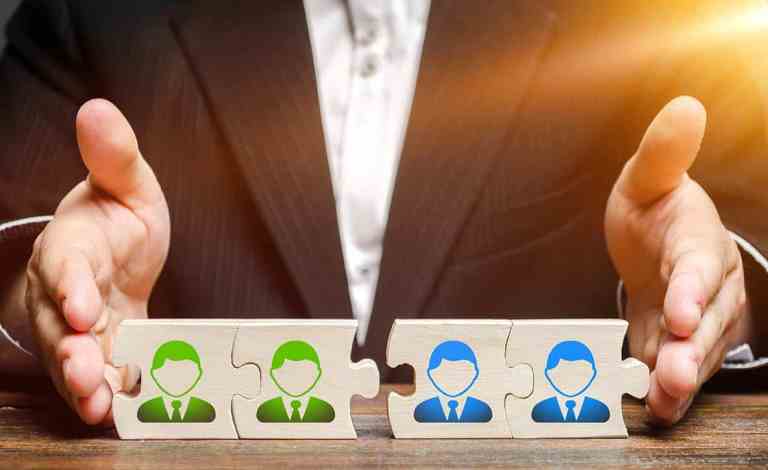 Businessman connects puzzles of workers employees in one group. Creation of an effective team of specialists for the implementation of a new project. HR management and recruiting.